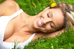 blond woman with large breasts lying in grass